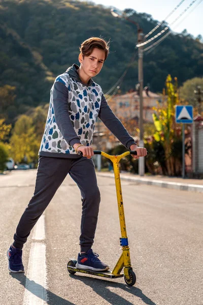 Adolescente Con Una Cara Seria Monta Scooter Camino Vacío Fondo —  Fotos de Stock