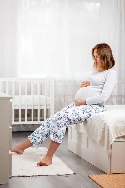 Eine Junge Schwangere Frau Sitzt Auf Dem Bett Und Hält — Stockfoto