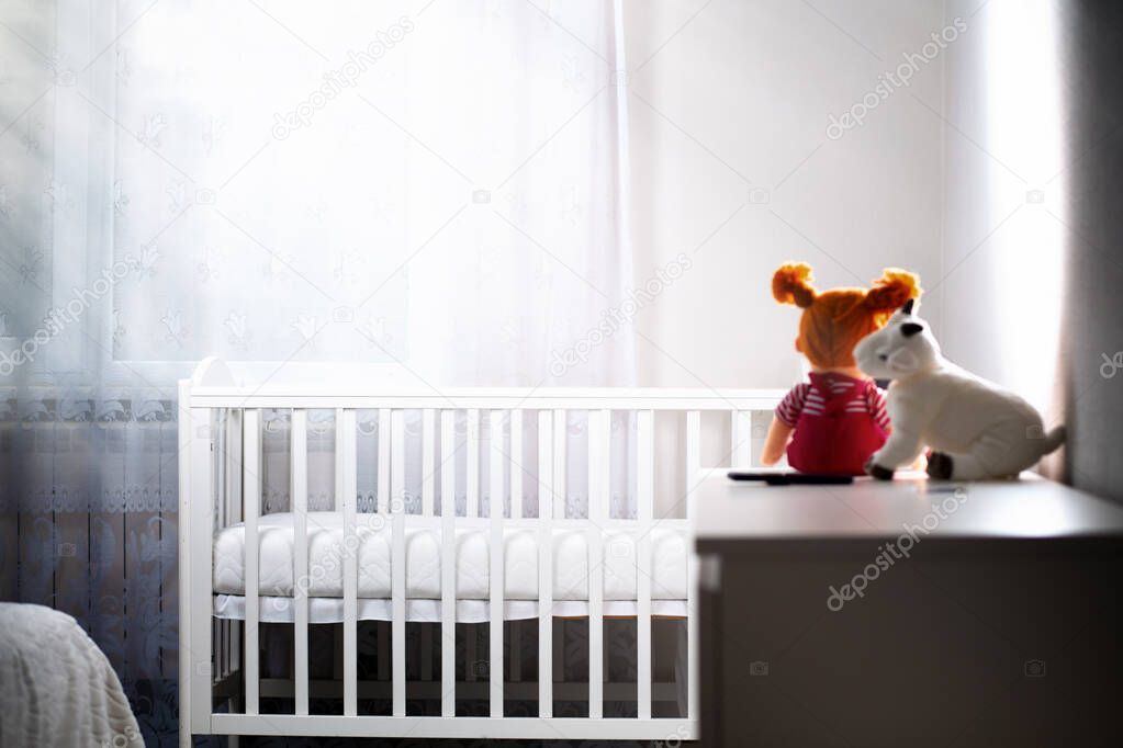 Children's room with an empty cradle and toys on the dresser. Copy space. The concept of abortion and female infertility.