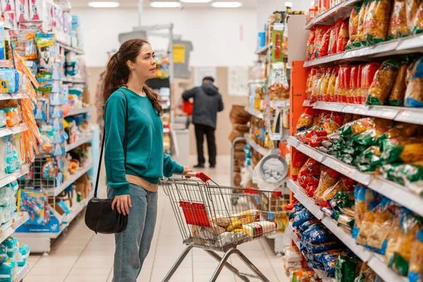 Uma Jovem Caucasiana Roupas Casuais Com Carrinho Supermercado Olha Para — Fotografia de Stock