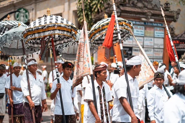 Galungan Tatili. Ellerinde şemsiyeler olan gençlerin geçit töreni. Bali Adası, Endonezya 26.12.2018.