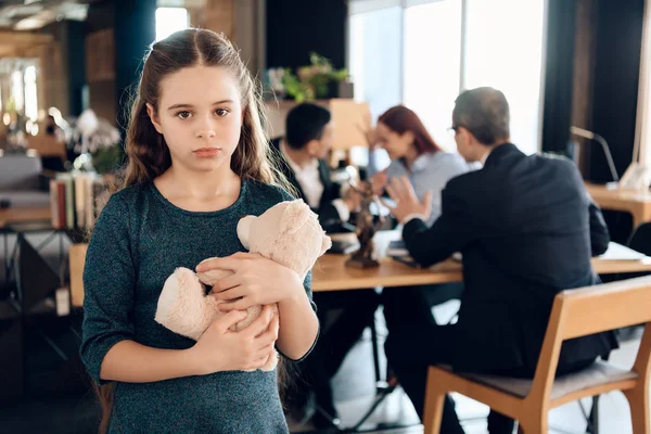 little girl hugging teddy bear at office of family lawyer