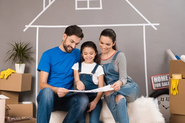 Familie Zoek Schema Van Nieuw Appartement Tijdens Zij Reparaties — Stockfoto