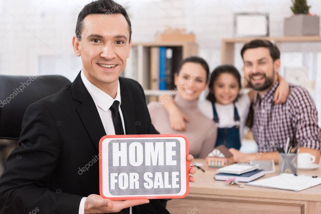 realtor holding sign home for sale in real estate agency 