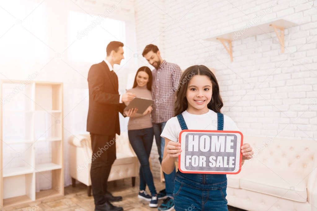 girl holding sign home for sale in real estate agency 