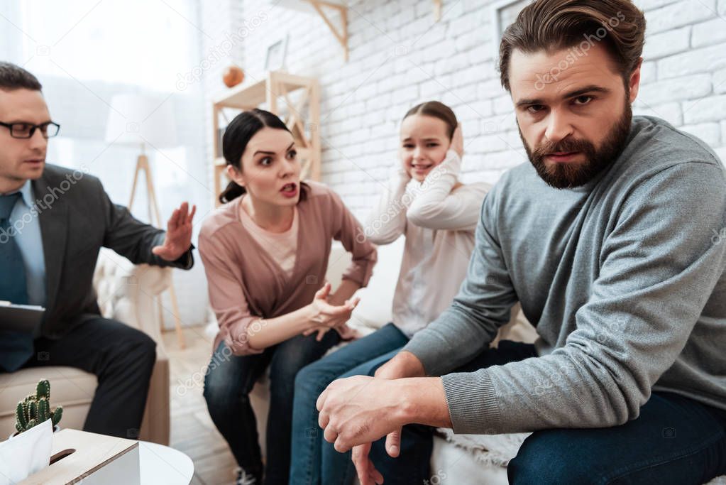 Adult couple with small daughter discuss problems in family at psychologist
