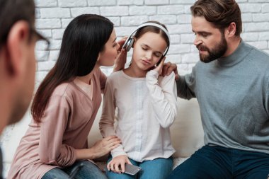 Hayal kırıklığına uğramış anne küçük kız kulaklık, Aile psikolog ile istişare için uzanarak çalışıyor