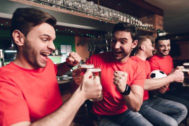 Futbol hayranları oyunu izlerken ve spor bar, kırmızı takım destekleyen, bira içmek