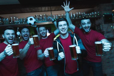 Futbol hayranları oyunu izlerken ve akşam spor barında bira içme Grup