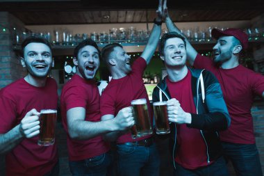 Futbol hayranları oyunu izlerken ve akşam spor barında bira içme Grup