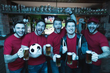 Futbol hayranları oyunu izlerken ve akşam spor barında bira içme Grup