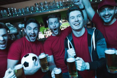 Futbol hayranları oyunu izlerken ve akşam spor barında bira içme Grup