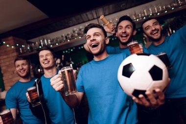 Futbol hayranları oyunu izlerken ve akşam spor barında bira içme Grup