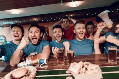 Kutluyor ve arka plan üzerinde üzgün rakipler ile spor barında tezahürat mavi takım taraftarları