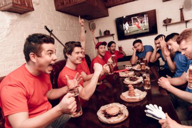 Kırmızı takım taraftarları spor barında üzgün oturan rakipler süre tezahürat