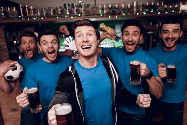 Futbol hayranları oyunu izlerken ve akşam spor barında bira içme Grup