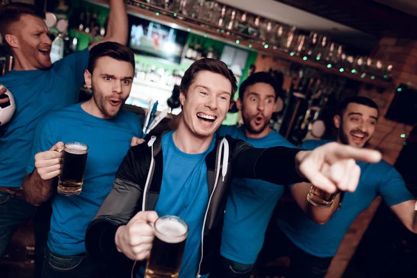 Futbol hayranları oyunu izlerken ve akşam spor barında bira içme Grup