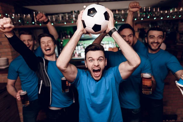 Futbol hayranları oyunu izlerken ve akşam spor barında bira içme Grup