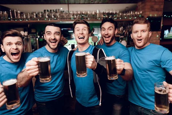 Futbol hayranları oyunu izlerken ve akşam spor barında bira içme Grup