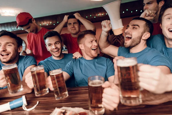 蓝色队球迷庆祝和欢呼在体育酒吧与哀伤的对手在背景上 — 图库照片