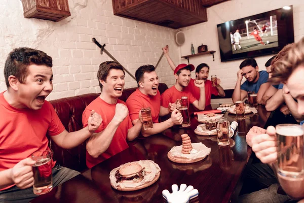 Červený Tým Fanoušci Povzbuzovali Při Soupeři Sedící Smutně Sport Bar — Stock fotografie