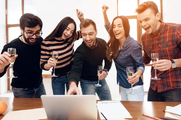 Young Office Workers Looking Laptop Screen Together Have Glasses Champagne — стоковое фото