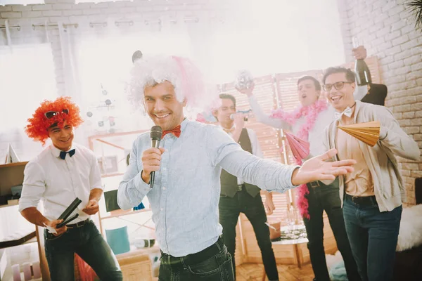 Hombres con ropa colorida cantando karaoke en la fiesta. —  Fotos de Stock