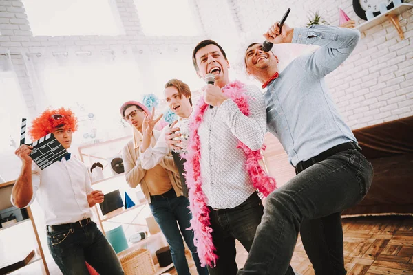 Män i färgglada kläder sjunger karaoke på festen. — Stockfoto