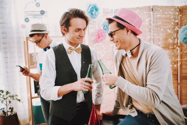 Partide iki eşcinsel şişe tokuşturur..