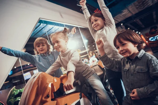 Niños alegres jugando videojuegos en la máquina tragaperras. — Foto de Stock