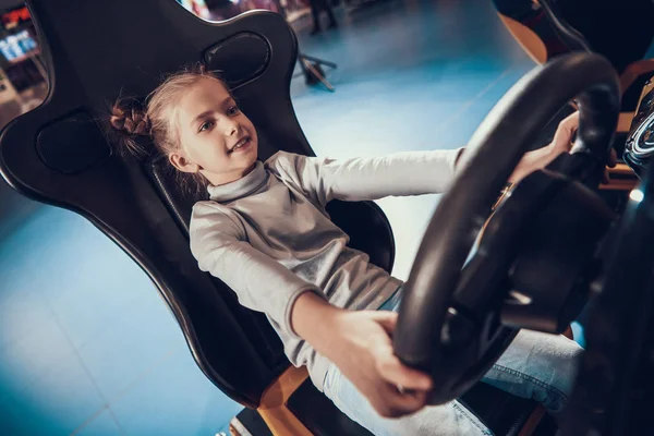 Fille assise au volant d'une machine de jeu. — Photo