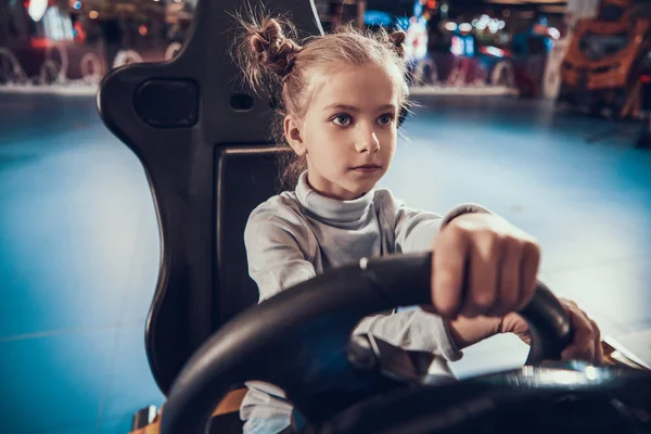 Fille assise au volant d'une machine de jeu. — Photo