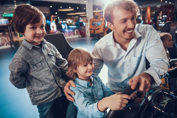 Pappa och söner spelar spelautomater i centrum. — Stockfoto