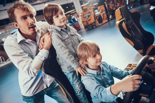 Pai e filhos jogando máquinas caça-níqueis no centro. — Fotografia de Stock