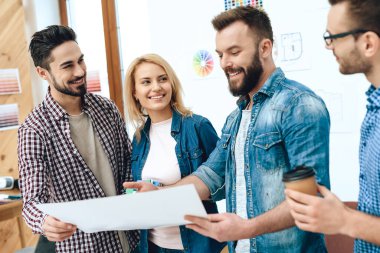 Bir adam gülümser ve bir şey gösterir.. 