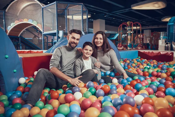 Uma jovem família veio à piscina com bolas.. — Fotografia de Stock