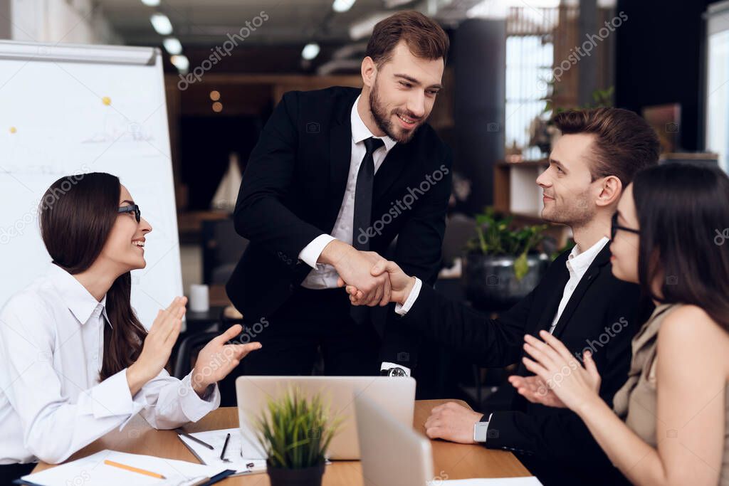 Man in suits shake hands for excellent work.