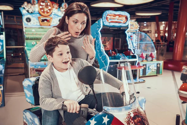 Mãe ficou com medo enquanto o filho dirige uma bicicleta de brinquedo. — Fotografia de Stock