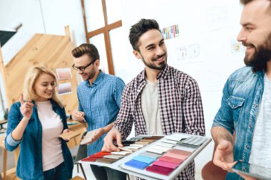 İki adam ayakta duruyor ve tasarım için yeni renkler seçiyor. 