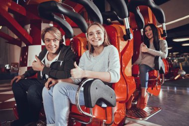Arkadaşlar lunaparkta kameraya bakıyorlar..