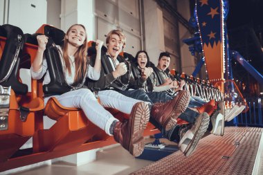 Gençler birlikte oturur ve gülümserler..