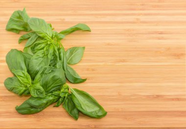 Birkaç dal taze yeşil fesleğen sol bambu kesme tahtası üzerinde bulunan