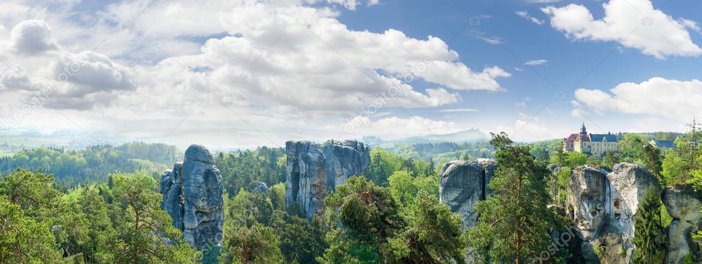 Panorama of the group of weathered rocks of sandstone among of the forest and old castle in reserve Bohemian Paradise, Czech Republic