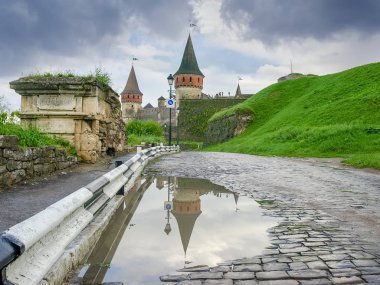 15. yüzyılda Kamianets Podilskyi kale Yağmur sonrası, Hmelnitski Oblastı, Ukrayna Kalesi ve eski şehir kapıları kalıntıları Kömür topakları yol kaplı