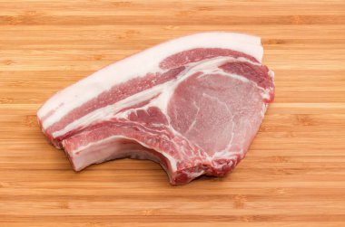 Pişmemiş Domuz loin pirzolası bambu kesme tahtası üzerinde kaburga ile