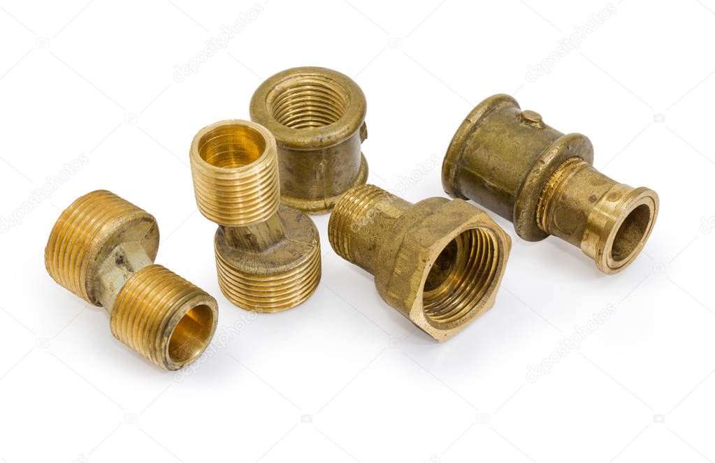Brass eccentric connectors, pipe couplings and other plumbing components on a white background