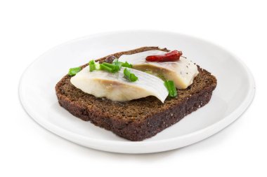 Açık kahverengi ekmek, dilim fileto Atlantik ringa turşusu, acı biber ve yeşil beyaz bir arka plan üzerinde seçici odak, bir uçan daire portre üzerinde yapılan sandviç 