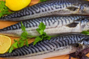 Dondurulmamış pişmemiş uskumru iskelet Yeşiller ve ahşap bambu kesme tahtası yakın çekim üzerinde limon ile bir parçasının arka plan