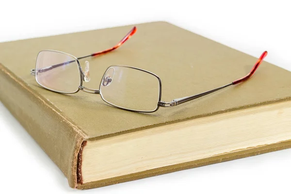 白い背景の選択と集中で閉じた古い本のクローズ アップの金属フレームで近代的な古典的なメンズ眼鏡 — ストック写真