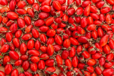 Arka plan ortaya konulan bir ahşap yüzeye kurutulmuş kırmızı gül kalça